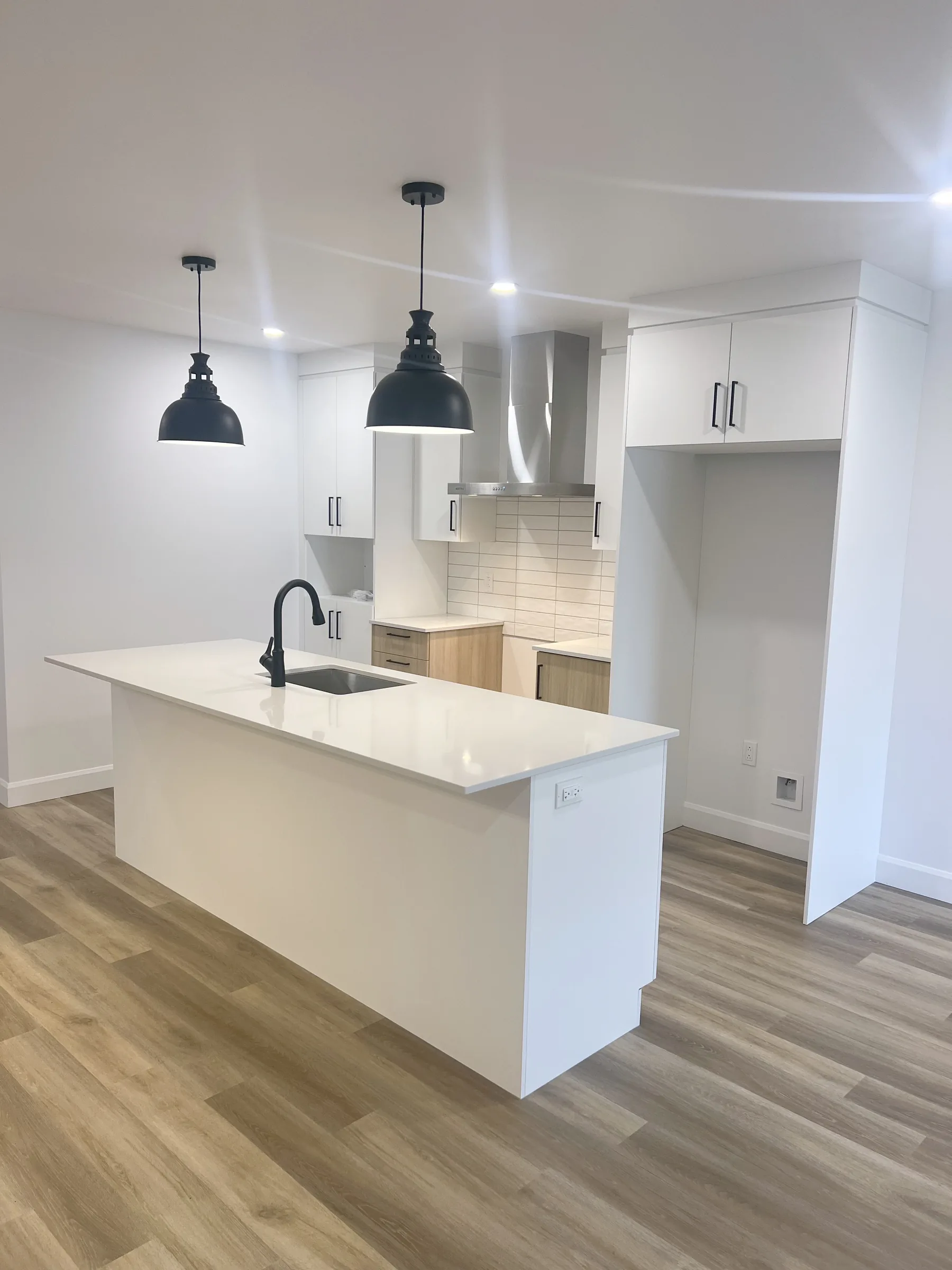 Apartment kitchen with a white island and pendant lights